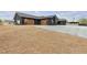 Modern black home with custom garage doors and an expansive gravel yard, providing style and functionality at 6235 N Fort Apache Rd, Las Vegas, NV 89149