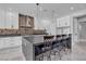 A modern kitchen boasts white cabinets, stainless steel appliances, stylish bar stool seating, and eye-catching backsplash at 6235 N Fort Apache Rd, Las Vegas, NV 89149