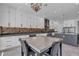 Modern kitchen and dining area with white cabinets, stainless appliances, and stylish backsplash at 6235 N Fort Apache Rd, Las Vegas, NV 89149