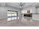 Bright living room with tile floors, an oversized ceiling fan, large sliding glass doors, and an open kitchen at 6235 N Fort Apache Rd, Las Vegas, NV 89149