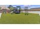 Artificial turf surrounds a backyard playground with slide, climbing wall, and swings at 6235 N Fort Apache Rd, Las Vegas, NV 89149