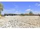 Large, undeveloped property with modern black home in the background offering future potential at 6235 N Fort Apache Rd, Las Vegas, NV 89149