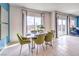 Bright dining area with a modern table, green chairs, and sliding glass doors at 7437 Cooper Cove Dr # 30, North Las Vegas, NV 89084