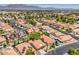 Bird's-eye view of a community showcasing terracotta roofs, solar panels, and mature landscaping at 7772 Buckwood Ct, Las Vegas, NV 89149