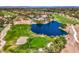 Breathtaking aerial view of golf course community featuring large pond and well-manicured greenery at 7772 Buckwood Ct, Las Vegas, NV 89149