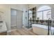 Contemporary bathroom with a shower, modern standalone tub, and decorative tile accent wall at 7772 Buckwood Ct, Las Vegas, NV 89149