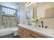 Bathroom features a dual sink vanity, and tub with tiled surround and accent tiling at 7772 Buckwood Ct, Las Vegas, NV 89149
