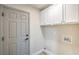 Laundry room with overhead cabinets, washer/dryer hookups, and door to garage at 7772 Buckwood Ct, Las Vegas, NV 89149