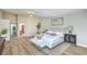 Spacious bedroom with wood floors, soft decor and a view into the ensuite bathroom at 7772 Buckwood Ct, Las Vegas, NV 89149