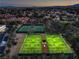 Aerial view of immaculately maintained tennis courts with lush landscaping and mountain views create an active resort-like setting at 7772 Buckwood Ct, Las Vegas, NV 89149