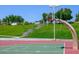 Outdoor basketball court in a community park with lush greenery and clear blue skies at 7820 Esteem St, Las Vegas, NV 89131