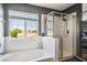 Bright bathroom featuring a separate tub and shower, with a large window offering natural light at 7820 Esteem St, Las Vegas, NV 89131