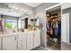Bathroom featuring a double vanity, large mirror, and closet with shelving at 7820 Esteem St, Las Vegas, NV 89131