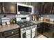 Modern kitchen with stainless steel appliances, dark cabinets, and granite countertops at 7820 Esteem St, Las Vegas, NV 89131