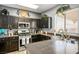 Well-lit kitchen with dark cabinets, granite countertops, stainless steel appliances, and a sink at 7820 Esteem St, Las Vegas, NV 89131