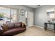 Cozy living room with sofa, ample natural light, and tile flooring for easy maintenance at 7820 Esteem St, Las Vegas, NV 89131