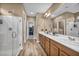 Bright bathroom featuring a double vanity, a glass-enclosed shower, and a large mirror at 9947 Fletcher Peak Ave, Las Vegas, NV 89178