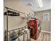 Well-lit laundry room features modern red appliances and ample storage for laundry essentials at 9947 Fletcher Peak Ave, Las Vegas, NV 89178