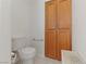 Neutral half-bathroom features a toilet, wood cabinet and tiled floors in a small space at 1900 Bellview St, Las Vegas, NV 89134