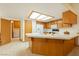Open kitchen boasts wood cabinets, tile countertops, and abundant natural light at 2040 Tucuman Ave, Pahrump, NV 89048