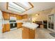 Bright eat-in kitchen features wood cabinets, tile countertops, and a skylight at 2040 Tucuman Ave, Pahrump, NV 89048