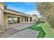 Beautiful backyard featuring artificial turf, desert landscaping, and large sliding doors to the home at 2170 Monte Bianco Pl, Henderson, NV 89044