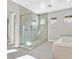 Bathroom boasts a glass-enclosed shower, soaking tub, light tile and neutral walls at 2170 Monte Bianco Pl, Henderson, NV 89044