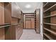 This large walk-in closet features custom shelving, multiple hanging racks, and several drawers at 2170 Monte Bianco Pl, Henderson, NV 89044