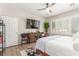 Well-lit bedroom boasting hardwood floors, large windows, TV, and ceiling fan at 2398 Jada Dr, Henderson, NV 89044