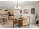 Cozy dining area features a glass-top table, chandelier, and is adjacent to the modern kitchen at 2398 Jada Dr, Henderson, NV 89044