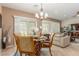 Cozy dining area with chandelier and slider, adjacent to the bright living area with plantation shutters at 2398 Jada Dr, Henderson, NV 89044