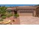 Charming home featuring a stone facade, two-car garage, and professionally landscaped front yard at 2398 Jada Dr, Henderson, NV 89044