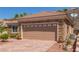 Home featuring a stone facade, two-car garage, and professionally landscaped front yard at 2398 Jada Dr, Henderson, NV 89044