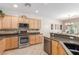 Gourmet kitchen featuring granite countertops, stainless steel appliances, and wood cabinets at 2398 Jada Dr, Henderson, NV 89044