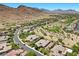 Panoramic aerial view showcasing the community with lush landscaping, golf course, and majestic mountain backdrop at 3048 Red Arrow Dr, Las Vegas, NV 89135