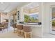 A stylish bar area featuring a black countertop, comfortable bar stools, and views of the greenery outside at 3048 Red Arrow Dr, Las Vegas, NV 89135