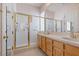 Bathroom with double sinks, a white-tile shower featuring gold trim, and a bright, airy feel at 3048 Red Arrow Dr, Las Vegas, NV 89135