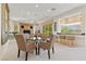 Bright dining room featuring a glass table, comfortable chairs, and a view of the outside greenery at 3048 Red Arrow Dr, Las Vegas, NV 89135