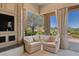 A bright sitting area with two armchairs and a picturesque view of the lush outdoor landscape at 3048 Red Arrow Dr, Las Vegas, NV 89135