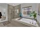 Bright bathroom features a soaking tub next to the glass shower and window at 333 Mandarin Hill Ln, Henderson, NV 89012