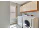 Laundry room featuring front load washer and dryer, overhead storage, and natural light at 364 Dooley Dr, Henderson, NV 89015