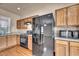 Traditional kitchen featuring wood cabinets, granite countertops, and modern black appliances at 3757 Via Geneva, Henderson, NV 89052