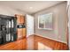 Eat in kitchen featuring wood floors, bright light and a black fridge at 3757 Via Geneva, Henderson, NV 89052