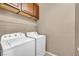 Well-lit laundry room includes a washer, dryer, and upper cabinets for storage at 3757 Via Geneva, Henderson, NV 89052