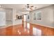 Open-concept living room featuring hardwood floors, a ceiling fan, and seamless flow into the kitchen at 3757 Via Geneva, Henderson, NV 89052