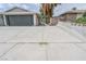 Long concrete driveway leading to a two-car garage, with a palm tree nearby at 4269 Roanridge Ave, Las Vegas, NV 89120