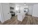 Open kitchen with stainless steel appliances, marble countertops, island and white cabinets at 4269 Roanridge Ave, Las Vegas, NV 89120