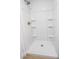 Bright white stand-up shower with built in shelving and bronze colored shower head at 4269 Roanridge Ave, Las Vegas, NV 89120