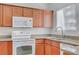 Well-lit kitchen featuring white appliances, wooden cabinets, and a modern faucet at 4400 S Jones Blvd # 1125, Las Vegas, NV 89103