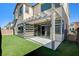 Inviting backyard features a covered patio and artificial grass, perfect for relaxing and entertaining outdoors at 532 Monarch Ridge Ct, North Las Vegas, NV 89084